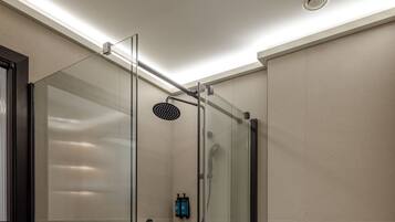 Un baño moderno con ducha de vidrio, inodoro y perchero para toallas.