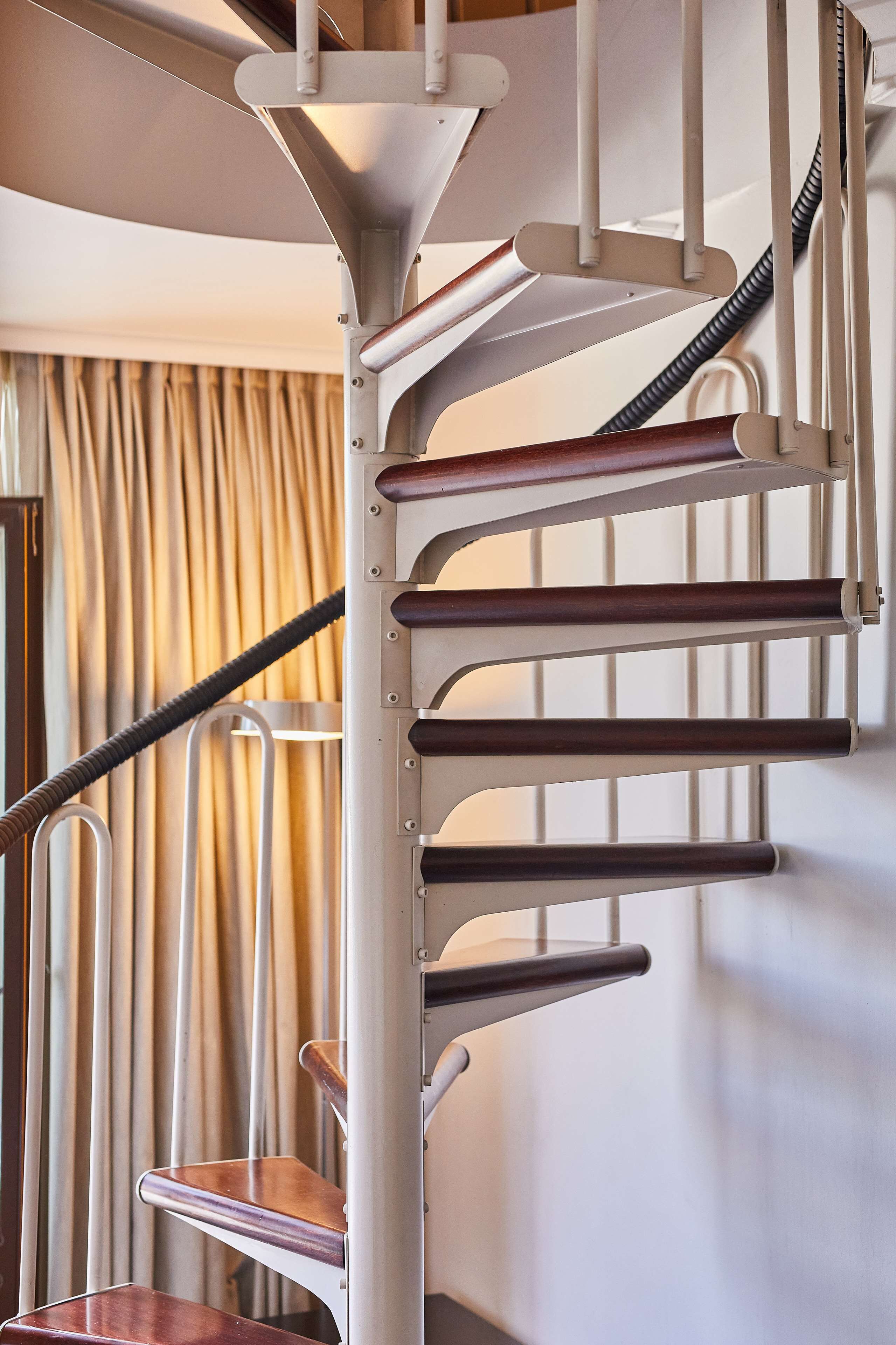 Una escalera de caracol con barandillas de metal y escalones de madera.