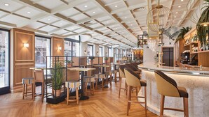 A modern bar area with wooden flooring, bar stools, and a counter with a marble top. - Hotel Silken Ciudad de Vitoria (Vitoria-Gasteiz)