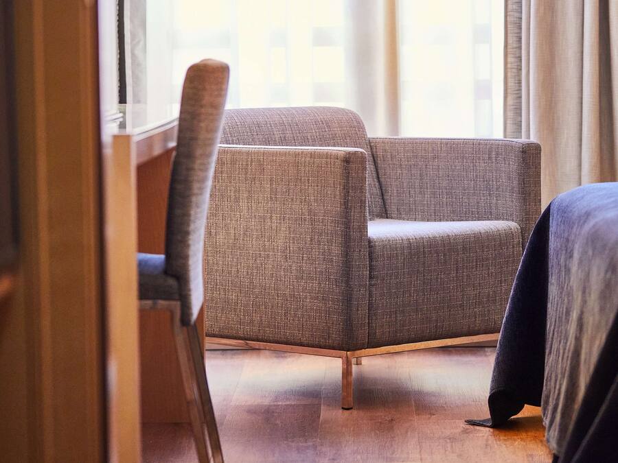 Ein Hotelzimmer mit einer Couch, einem Sessel und einem Bett.