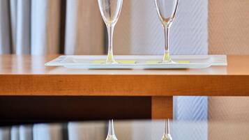 Dos copas de vino vacías sobre una mesa de madera con una superficie reflectante debajo.