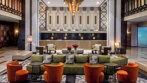 A modern lobby with a reception desk, seating area, and decorative wall panels. - Hilton Addis Ababa (Addis Ababa)