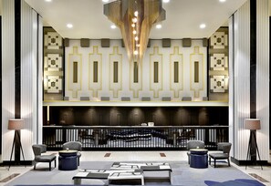 A lobby with a modern design, featuring a central staircase, seating area, and a chandelier. - Hilton Addis Ababa (Addis Ababa)