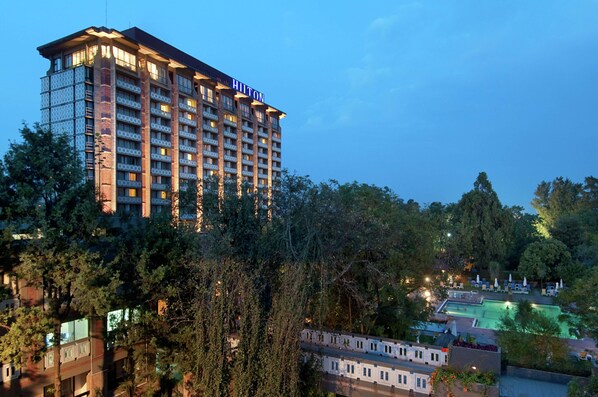 A multi-story hotel with the name "HITON" on the facade, surrounded by trees and featuring a swimming pool area. - Hilton Addis Ababa (Addis Ababa)