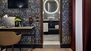 A modern bathroom with a large mirror, a sink, and a television mounted on the wall. - Hotel American Dinesen (Venice)
