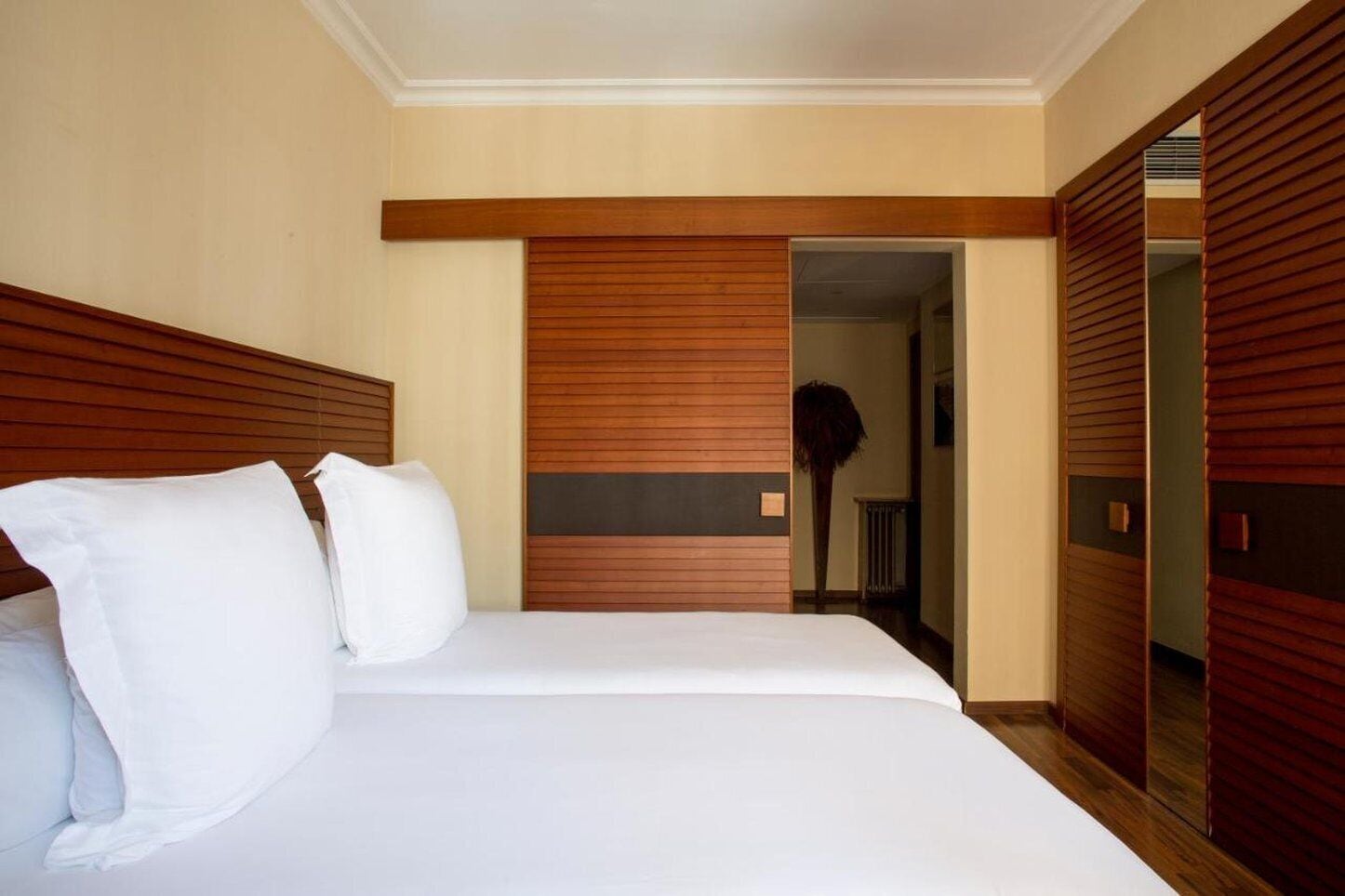 Una habitación de hotel con cama, cabecero de madera y armario.