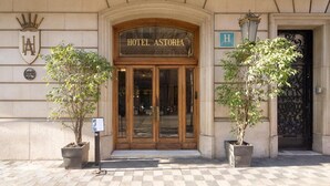 La entrada del Hotel Astoria, con una fachada clásica, puertas dobles y un cartel sobre la entrada.