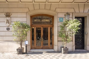 Entrada do Hotel Astoria com fachada clássica, portas duplas e uma placa acima da entrada.