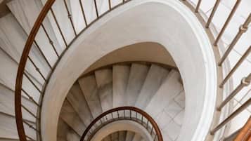 Una escalera de caracol con barandillas de madera y peldaños blancos.