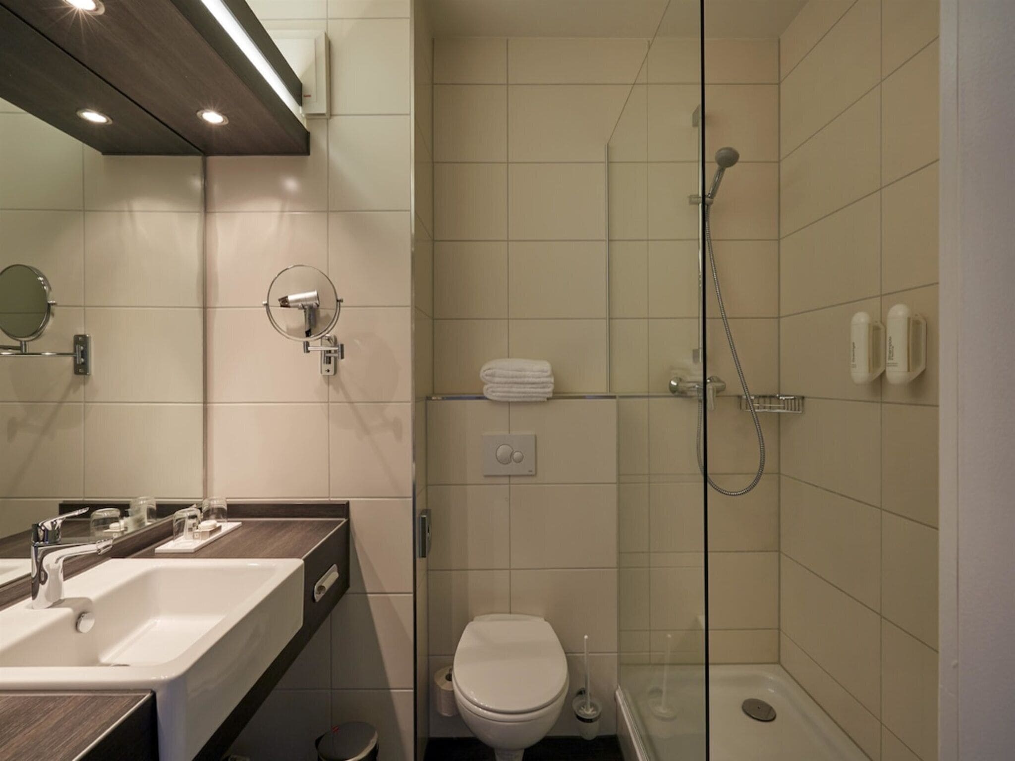 Un baño moderno con ducha, inodoro y lavabo.