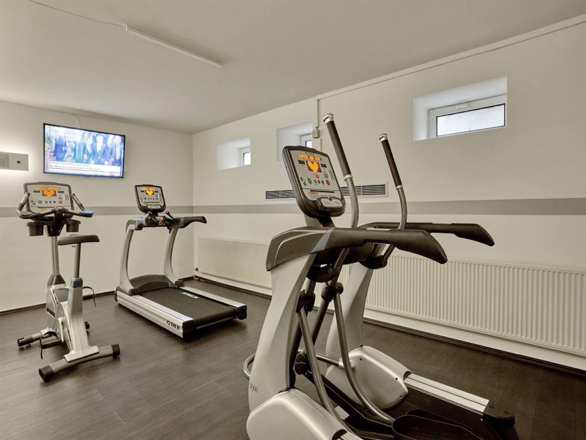 A fitness room with treadmills and elliptical machines.