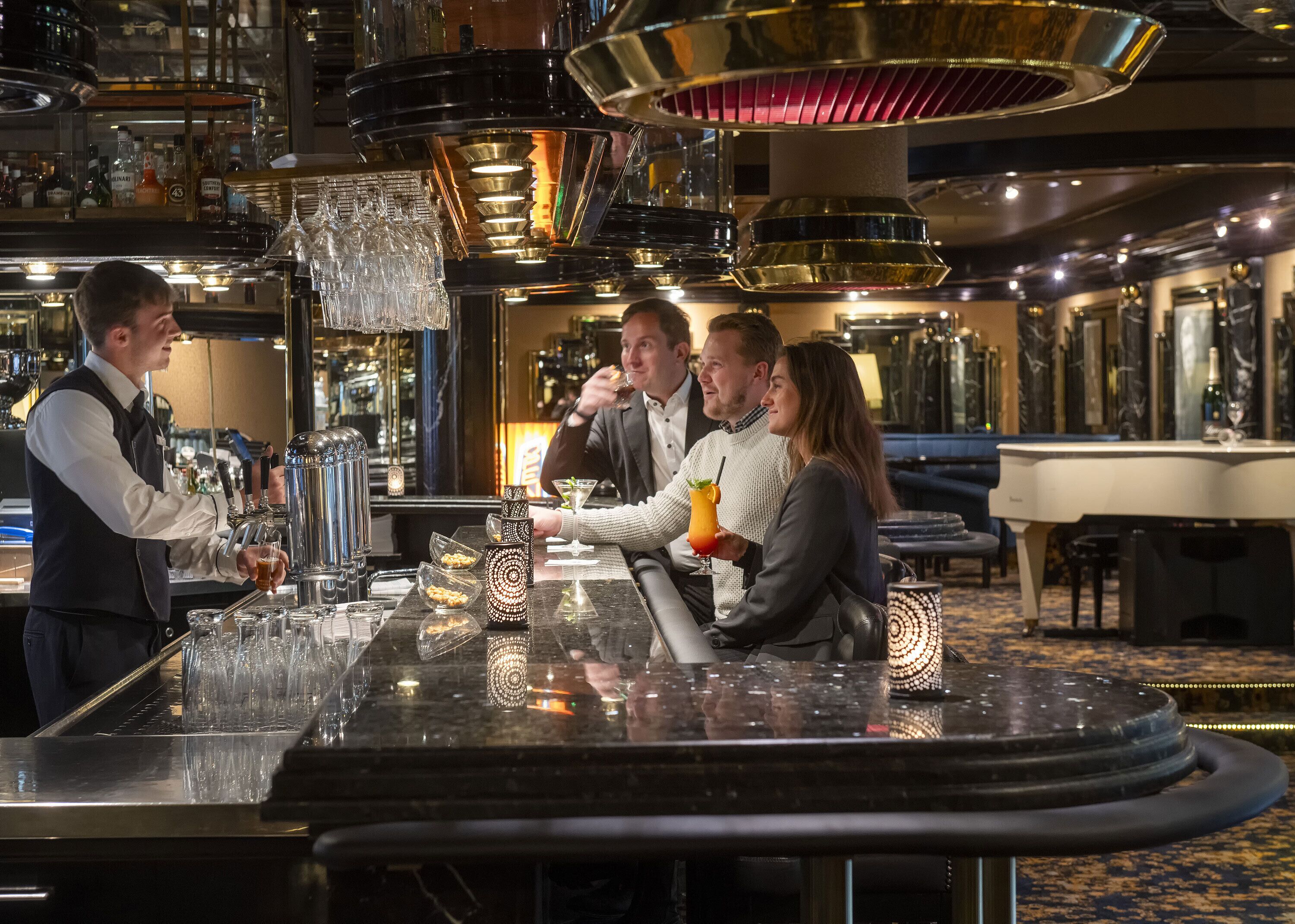 A bar area with a bartender, a seated couple, and a bar counter with glasses and bottles.