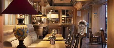 Ein Restaurant mit Holztischen und -stühlen, einer dekorativen Lampe und einer Kreidetafel mit Speisekarte.