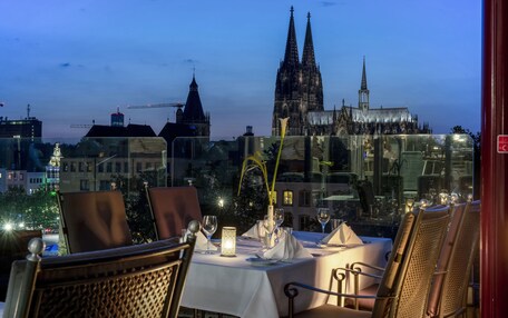 A table set for dining with a view of a cathedral in the background.