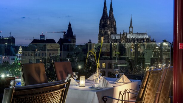 A table set for dining with a view of a cathedral in the background.