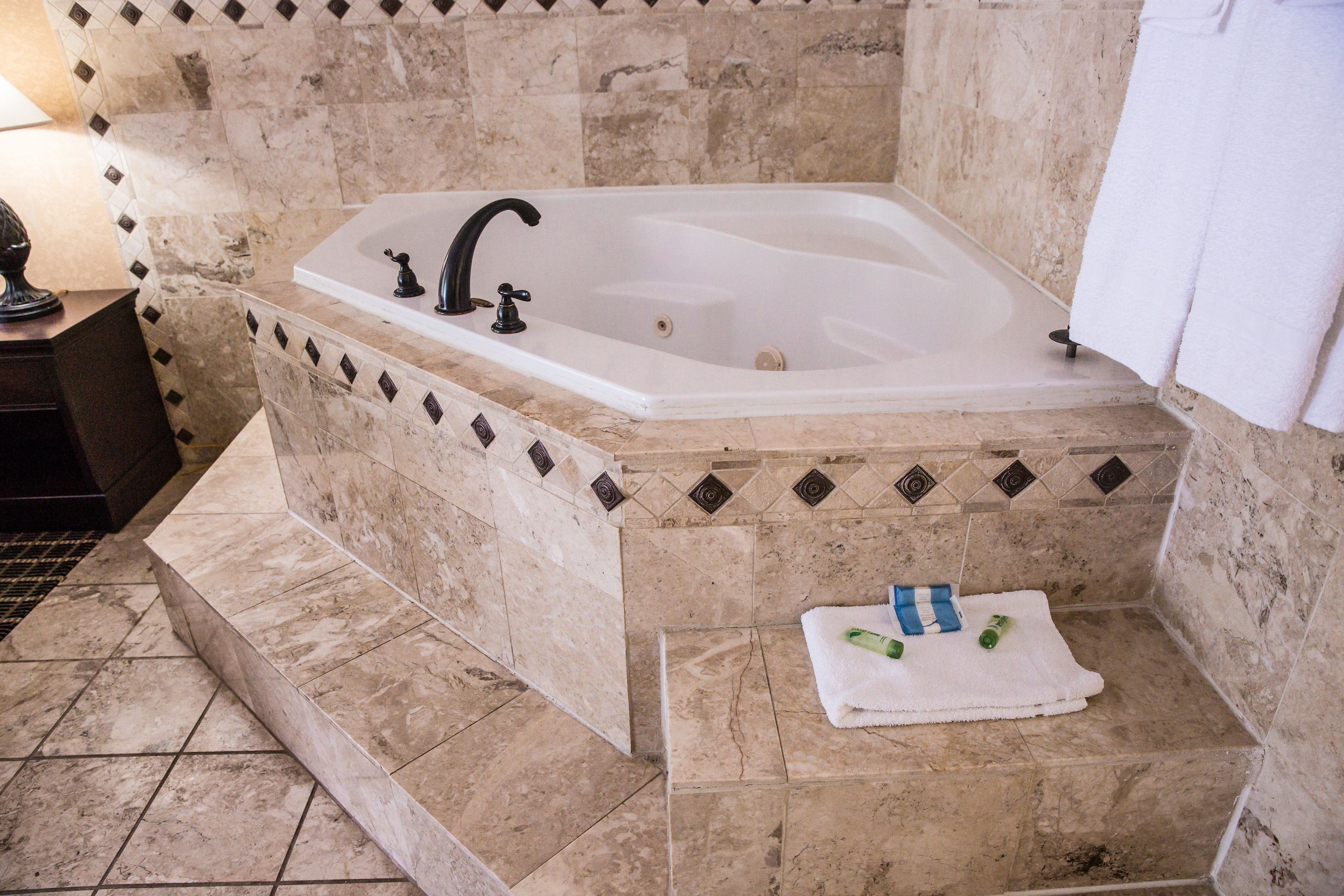 A bathroom with a freestanding bathtub, a towel, and toiletries.