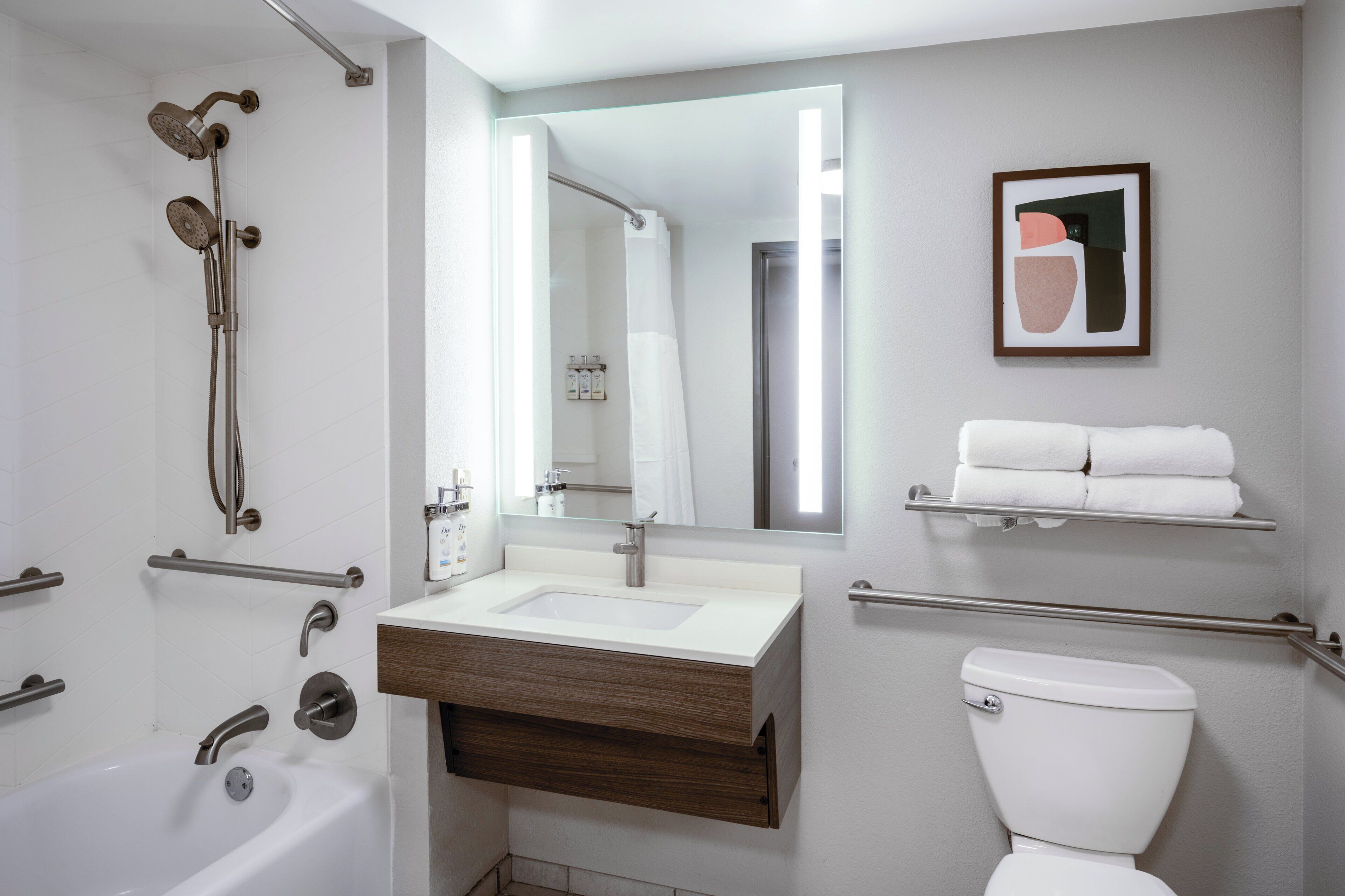 A modern bathroom with a bathtub, a sink, a toilet, and a shower.