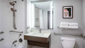 A modern bathroom with a bathtub, a sink, a toilet, and a shower.