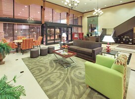 Un salón amplio con sofá, sillones, una mesa de centro y un comedor.