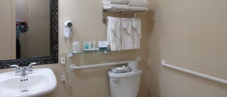A bathroom with a sink, toilet, towel rack, and a mirror.