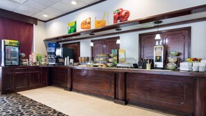 A hotel reception area with a counter, various food items, and a refrigerator. - Quality Inn Oneonta Cooperstown Area (Oneonta)