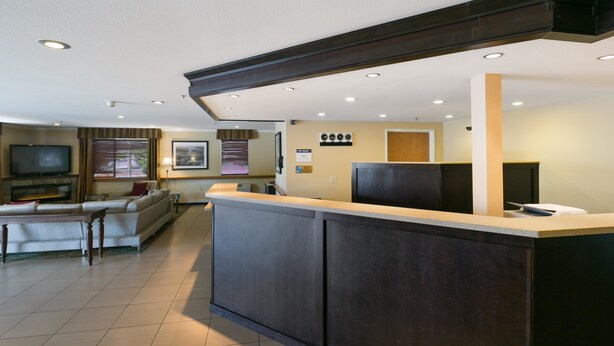 A modern hotel lobby with a reception desk, a seating area with a sofa and armchairs, a flat-screen TV, and a fireplace. - Best Western Tumwater-Olympia Inn (Olympia)