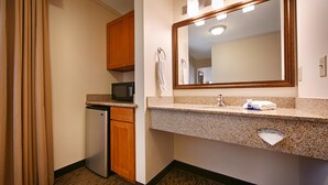 A compact hotel bathroom with a kitchenette, including a microwave, refrigerator, and sink with a vanity mirror. - Best Western Tumwater-Olympia Inn (Olympia)