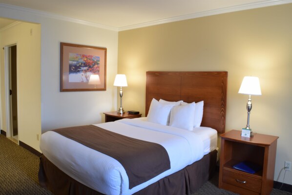 A hotel room with a large bed, two bedside tables with lamps, a framed picture on the wall, and a carpeted floor. - Best Western Tumwater-Olympia Inn (Olympia)