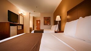 A hotel room with a large bed, a television, a microwave, and a painting on the wall. - Best Western Tumwater-Olympia Inn (Olympia)