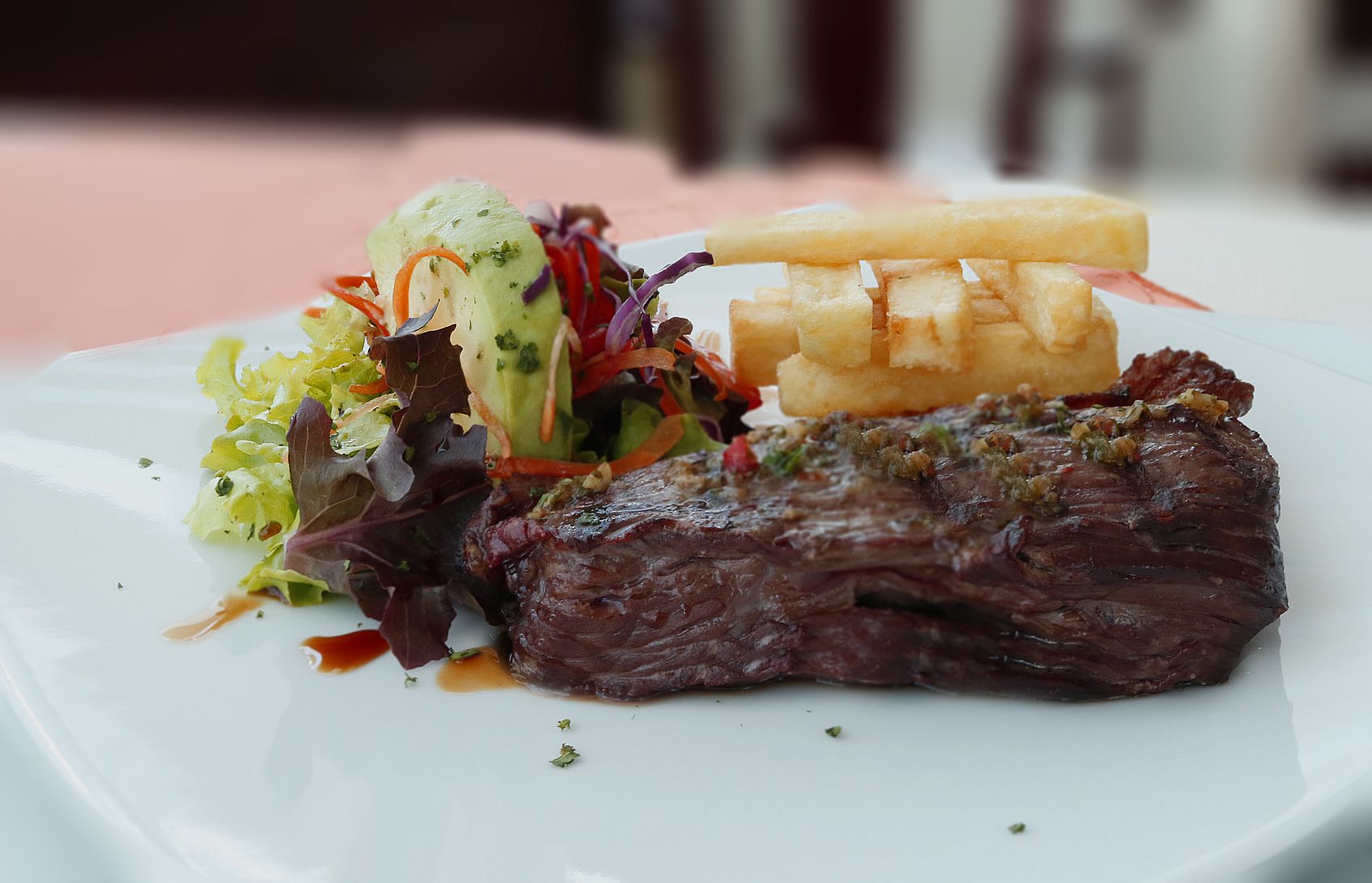 Une assiette avec un steak, des frites et une salade.