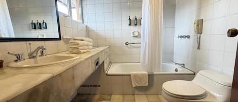 Une salle de bain équipée d’un lavabo, d’une baignoire, de toilettes et d’un miroir.