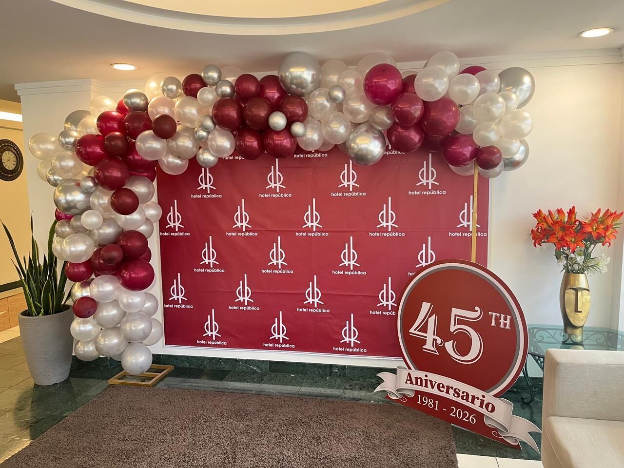 A hotel lobby with a red backdrop featuring the hotel's logo and a 45th anniversary banner.