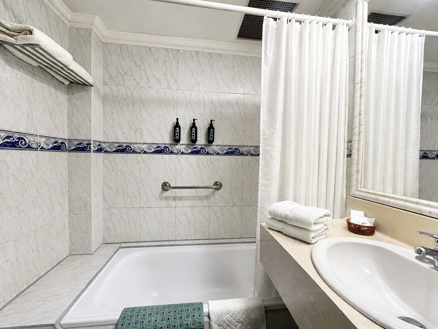 A bathroom with a bathtub, a shower area, and a sink.