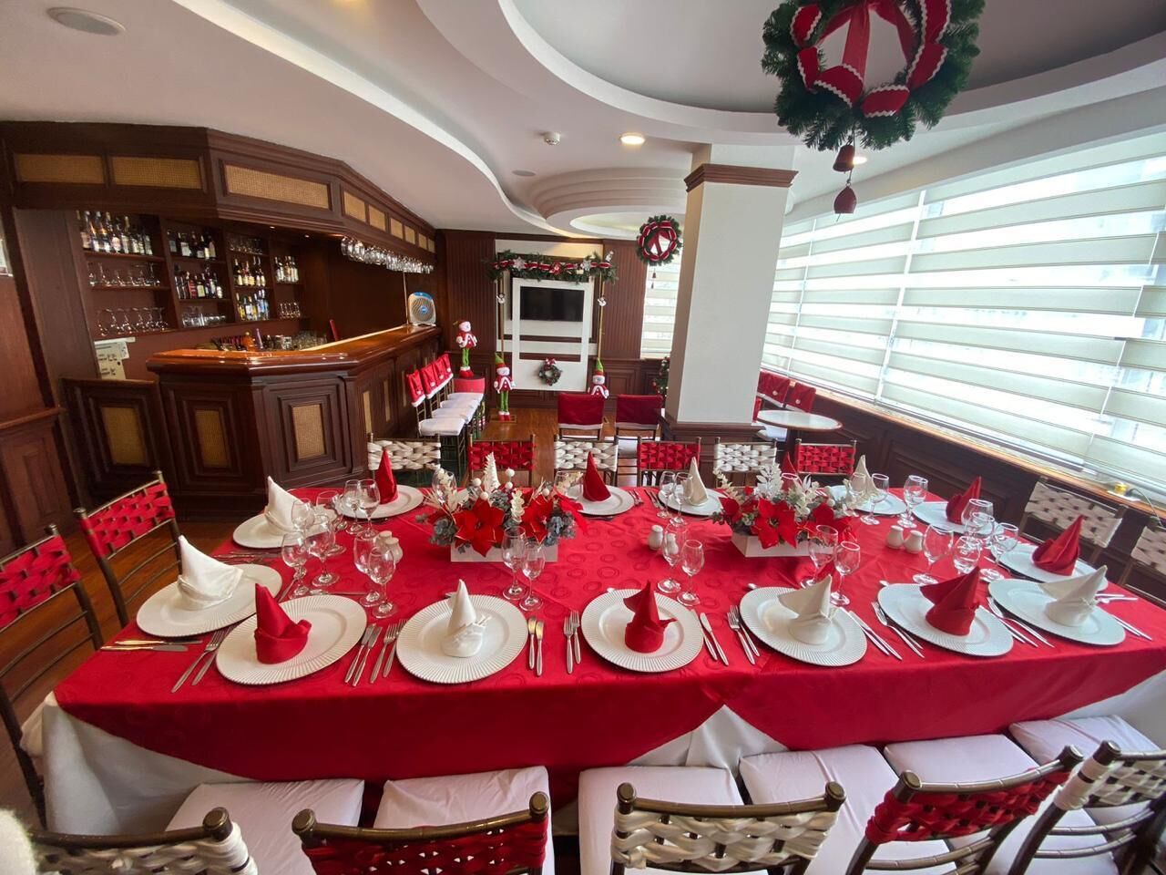 A dining area with red tablecloths, white napkins, and festive decorations.