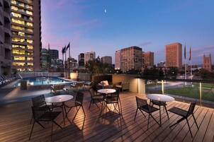 Una piscina al aire libre, sillones reclinables de piscina