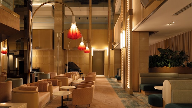A hotel lobby with a grand piano, multiple seating areas, and a patterned carpet. - Amora Hotel Adelaide (Adelaide)