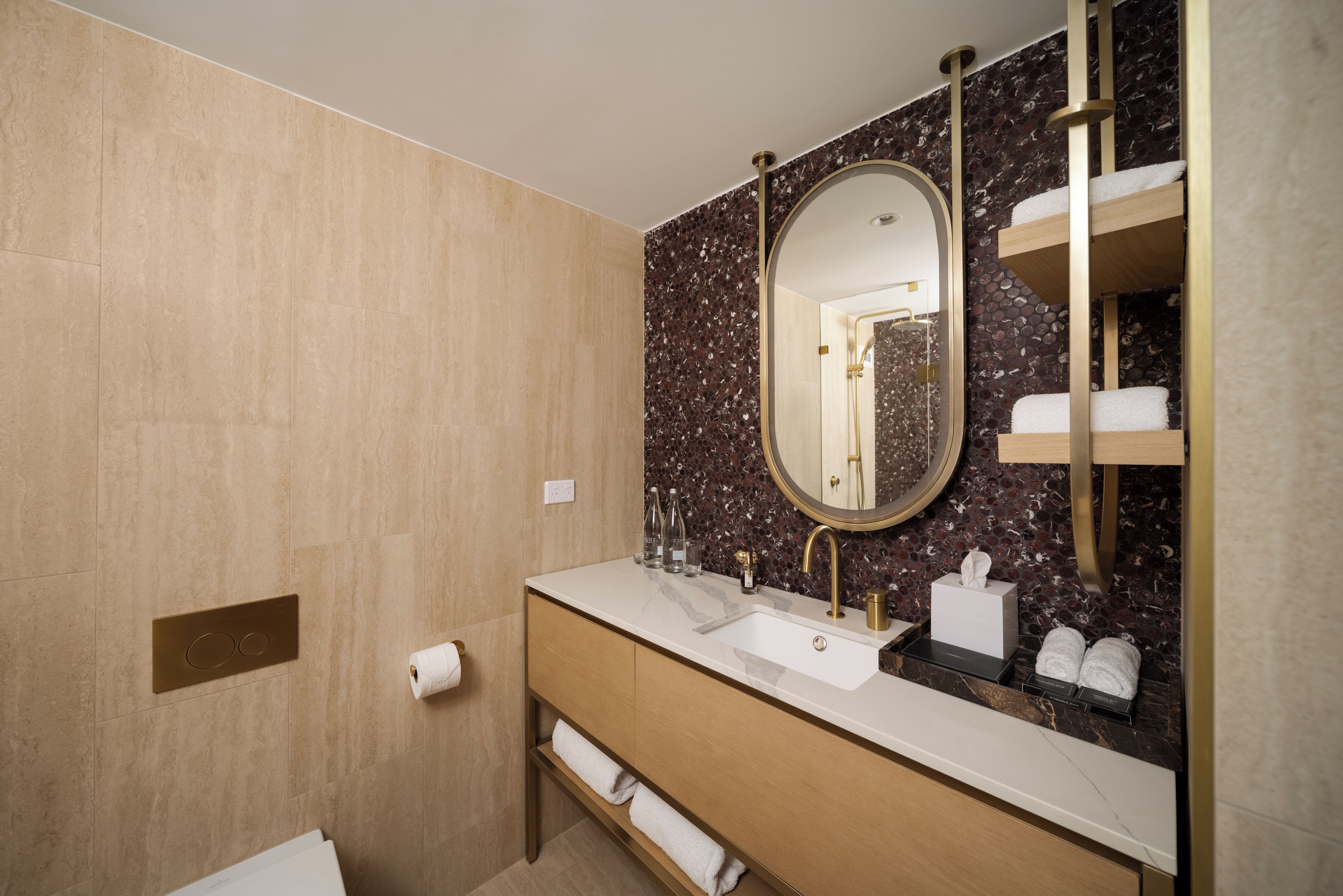 A modern bathroom with a marble vanity, a large mirror, and a shower area.