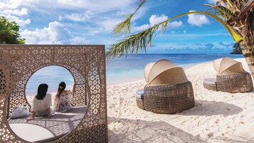 On the beach, white sand, free beach cabanas, beach umbrellas