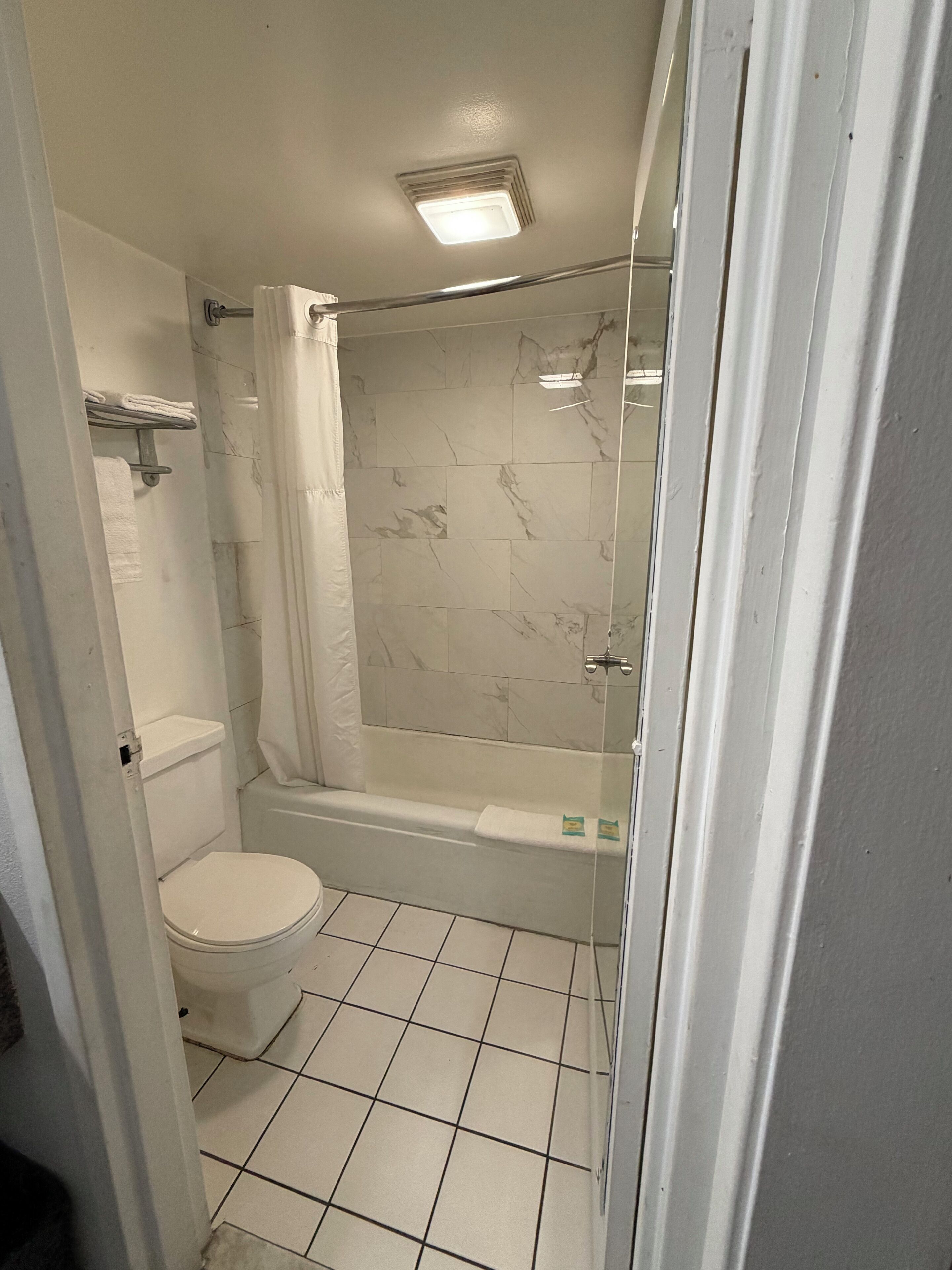 A bathroom with a toilet, a shower with a glass door, and a bathtub.