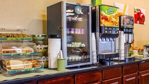 Ein Bereich für das Frühstück mit Selbstbedienung, inklusive Kühlschrank, Kaffeeautomaten und verschiedenen Speisen.
