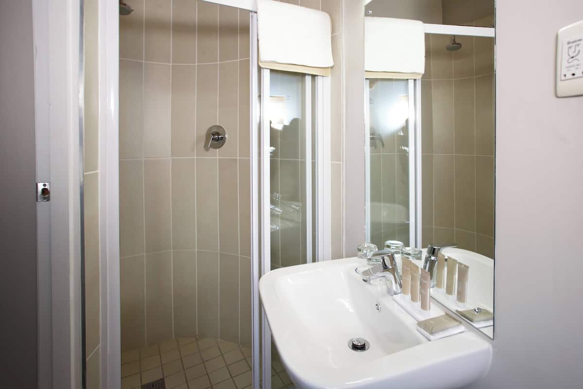 Ein Badezimmer mit Waschbecken, Spiegel und Dusche.