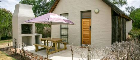 A house with a patio, a wooden door, and a stone pathway.
