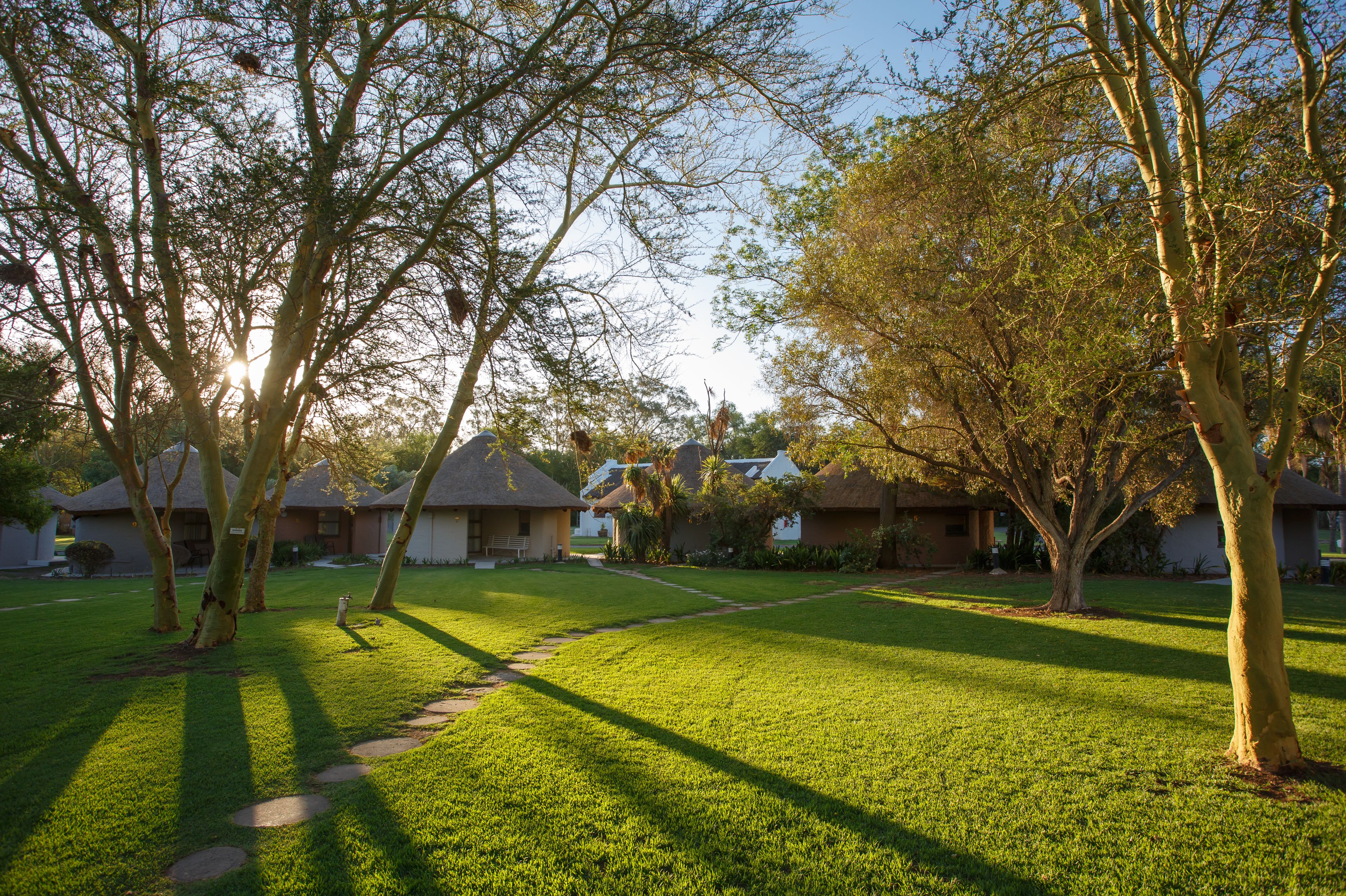 Zona residencial con casas, césped cuidado y un sendero.