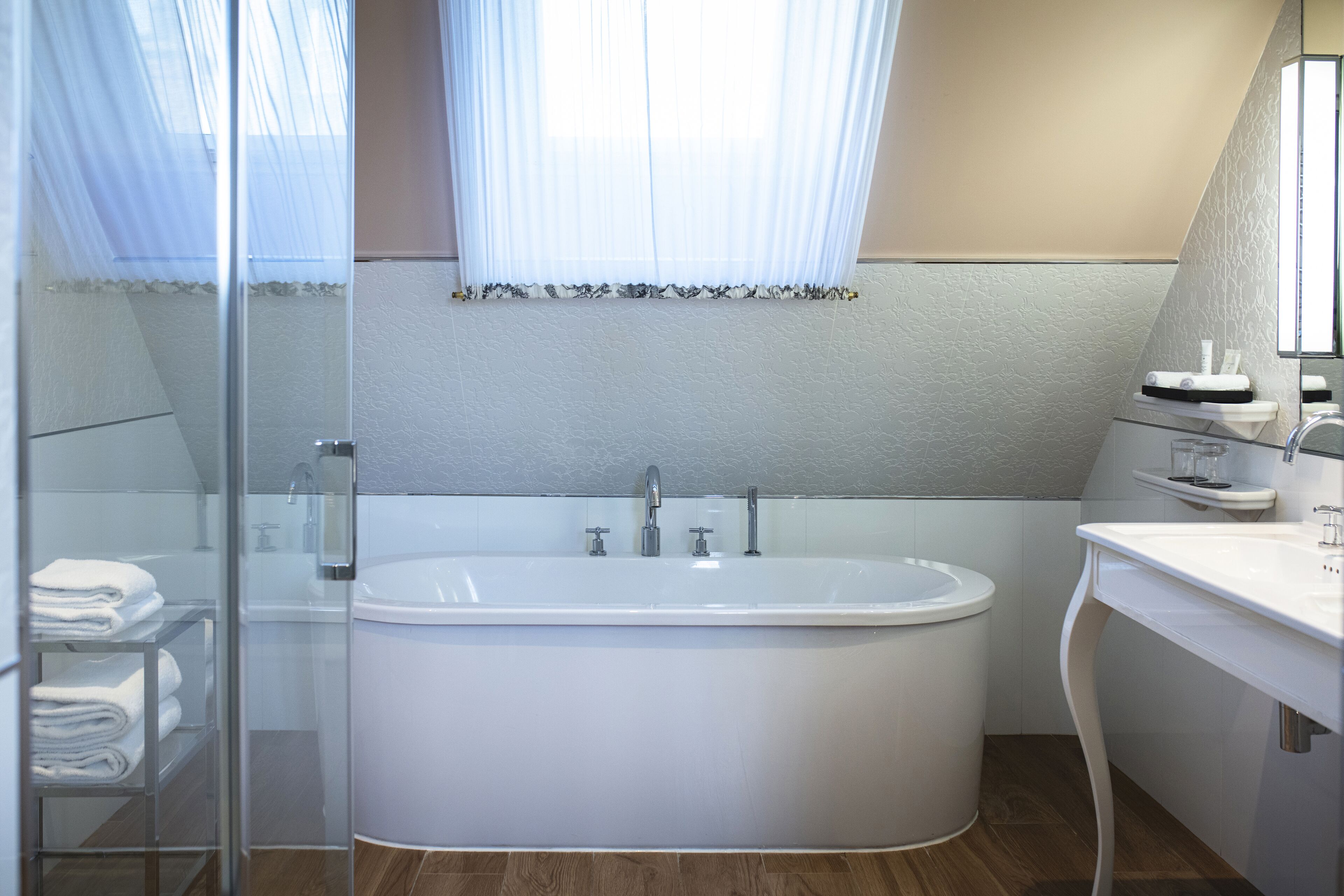 A modern bathroom with a freestanding bathtub, a glass shower enclosure, and a vanity with a mirror.