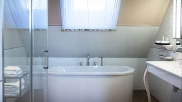 A modern bathroom with a freestanding bathtub, a glass shower enclosure, and a vanity with a mirror.