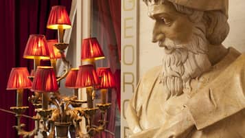 A bust of a historical figure with a decorative lamp in front of it.