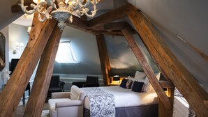 A cozy attic bedroom with a bed, a chair, and a desk.