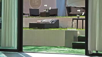 A pool area with a view of a garden and outdoor seating.