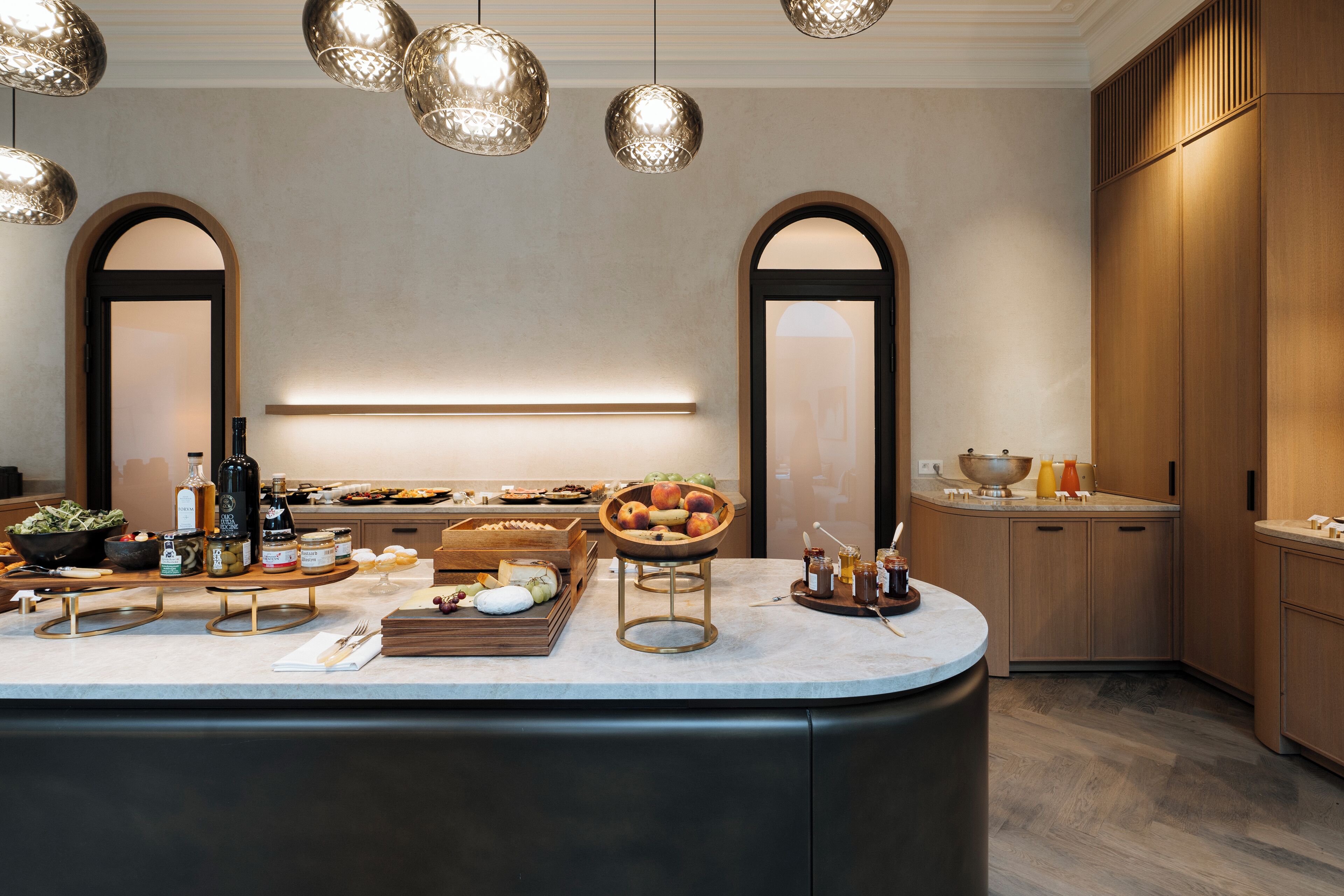 A modern kitchen with a central island, wooden cabinets, and pendant lighting.