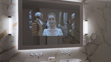 A bathroom with a large mirror, two sinks, and marble walls.